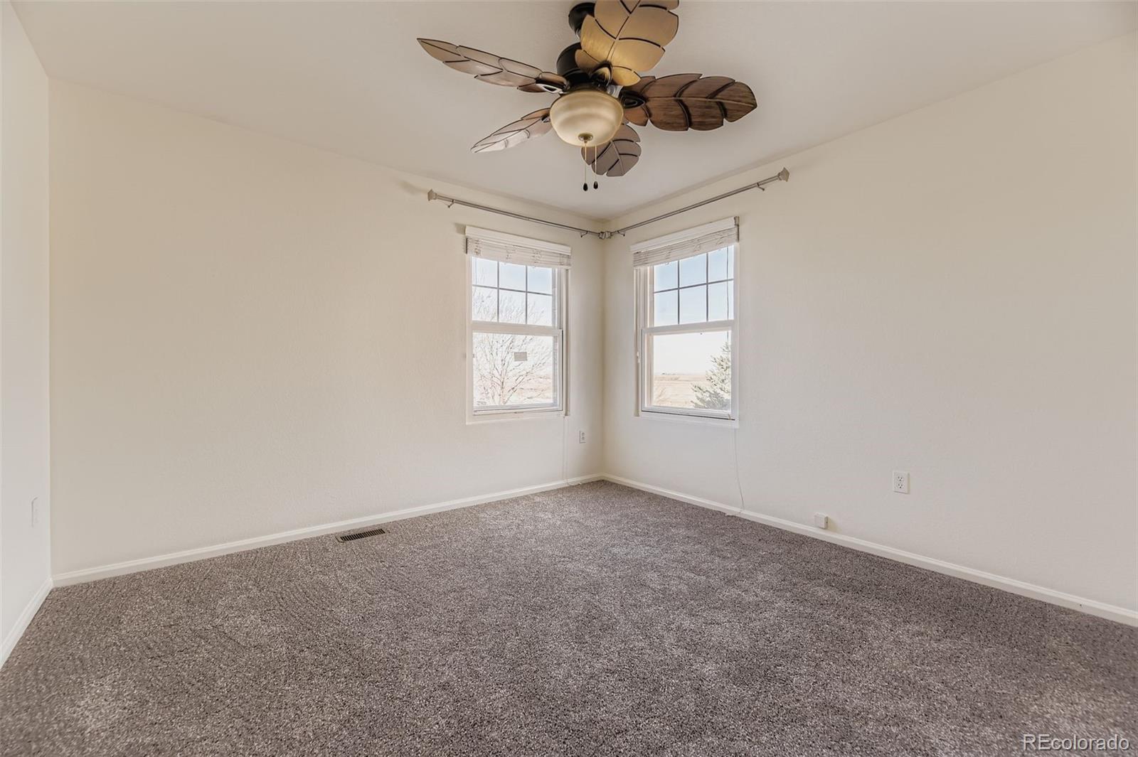 2430 South Jebel Way Aurora, CO 80013 - Photo 19 of 28 an empty room with windows and ceiling fan