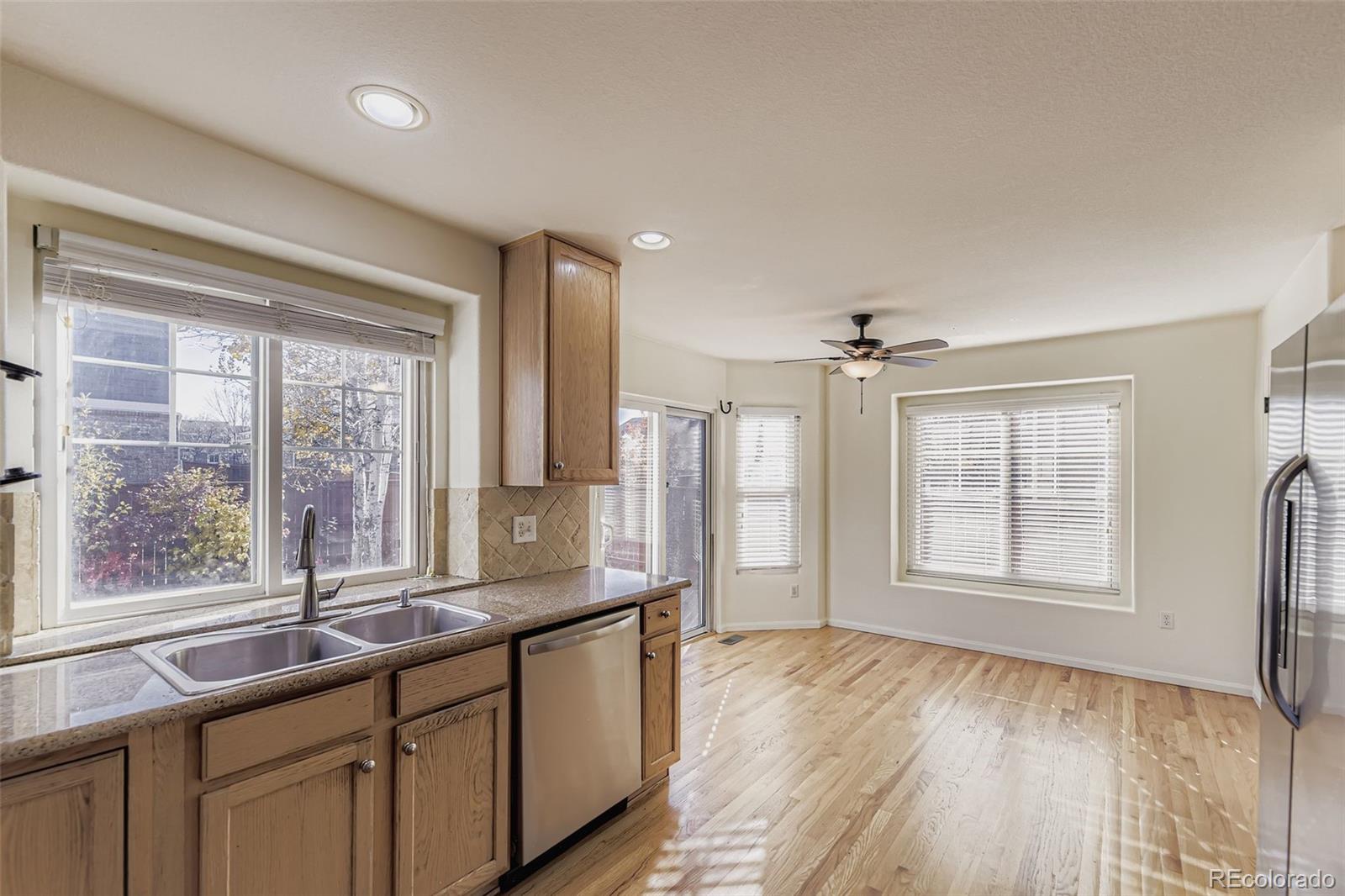 2430 South Jebel Way Aurora, CO 80013 - Photo 10 of 28 a view of a big room with windows and chandelier fan