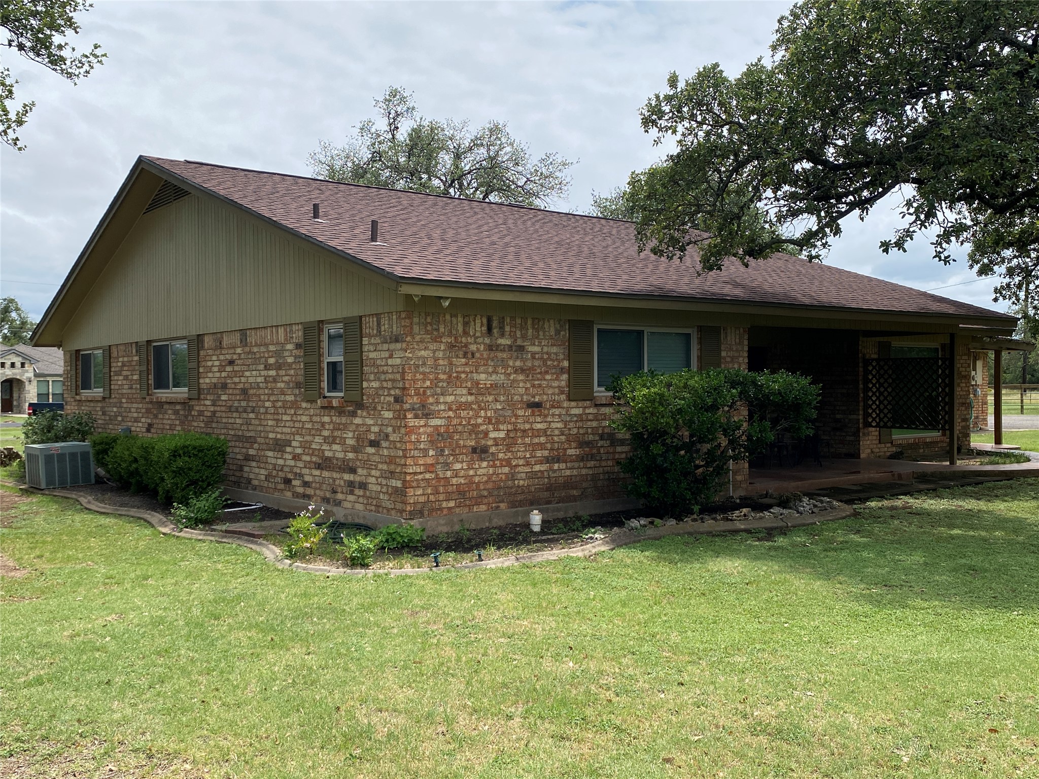 140 Oak Ridge Road Georgetown, TX 78628 - Photo 11 of 39 View of property exterior featuring brick siding, a lawn, and a shingled roof