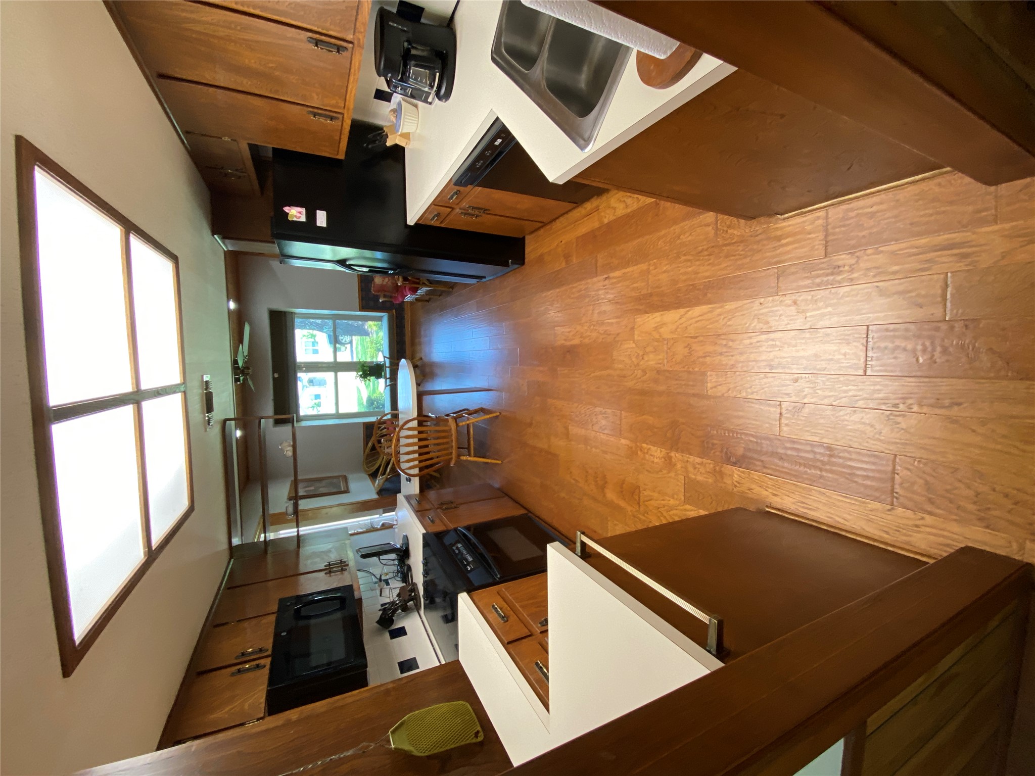 140 Oak Ridge Road Georgetown, TX 78628 - Photo 27 of 39 Kitchen featuring light countertops, black appliances, a ceiling fan, light wood finished floors, and wood finish cabinets