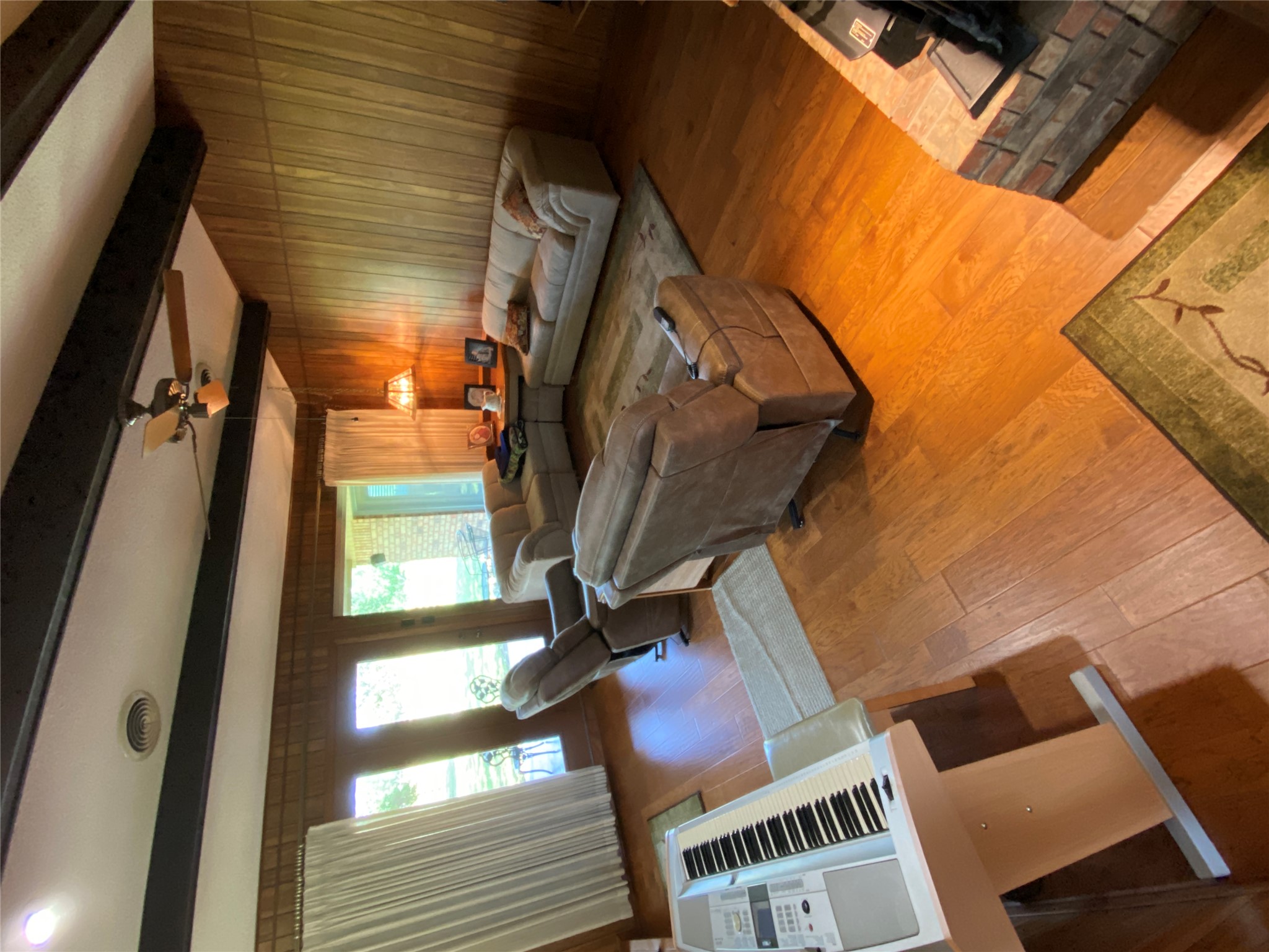 140 Oak Ridge Road Georgetown, TX 78628 - Photo 29 of 39 Living area featuring ceiling fan, wood finished floors, beamed ceiling, and wood walls