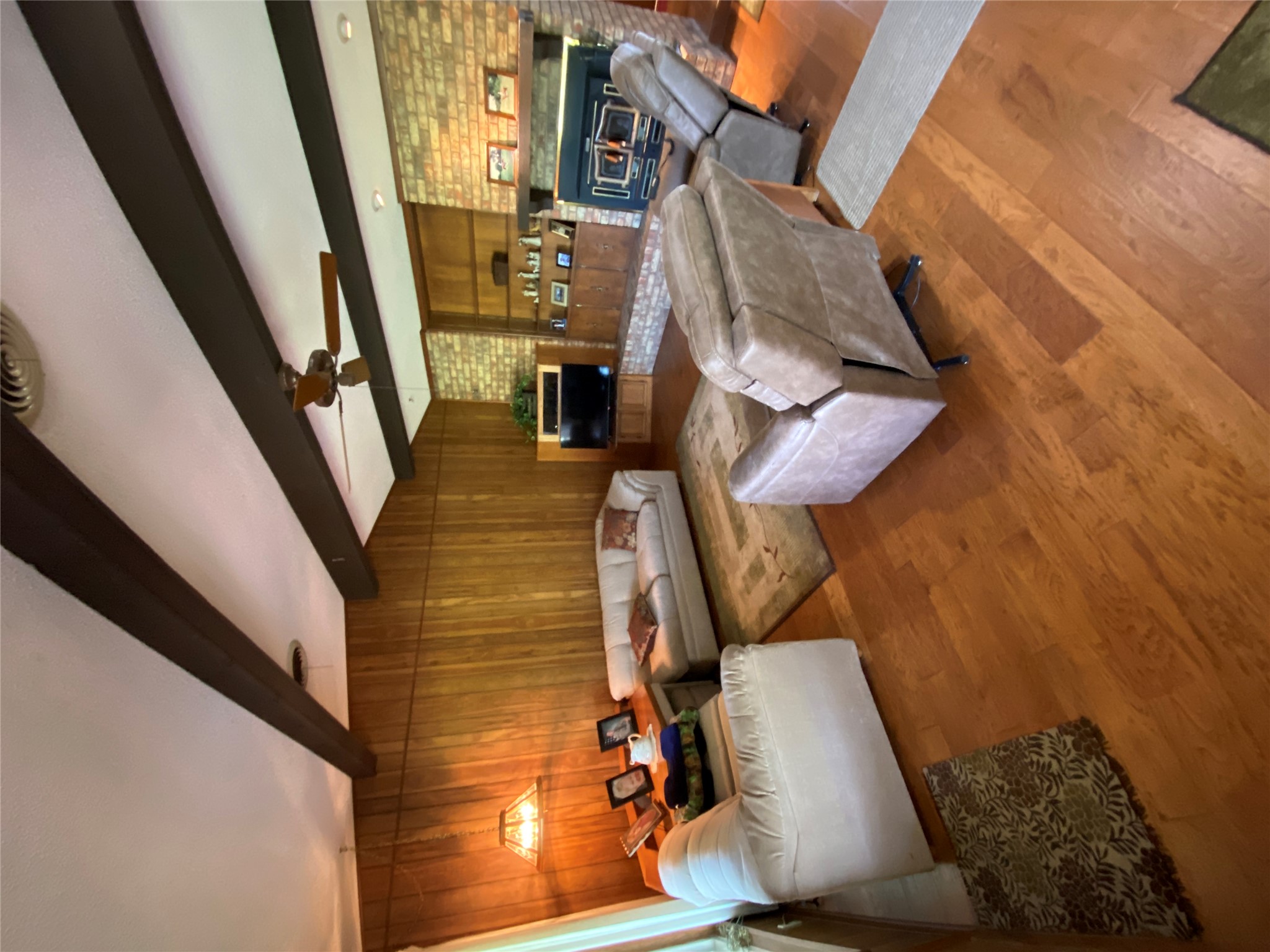 140 Oak Ridge Road Georgetown, TX 78628 - Photo 30 of 39 Living area with hardwood / wood-style floors, beamed ceiling, wood walls, brick wall, and a ceiling fan
