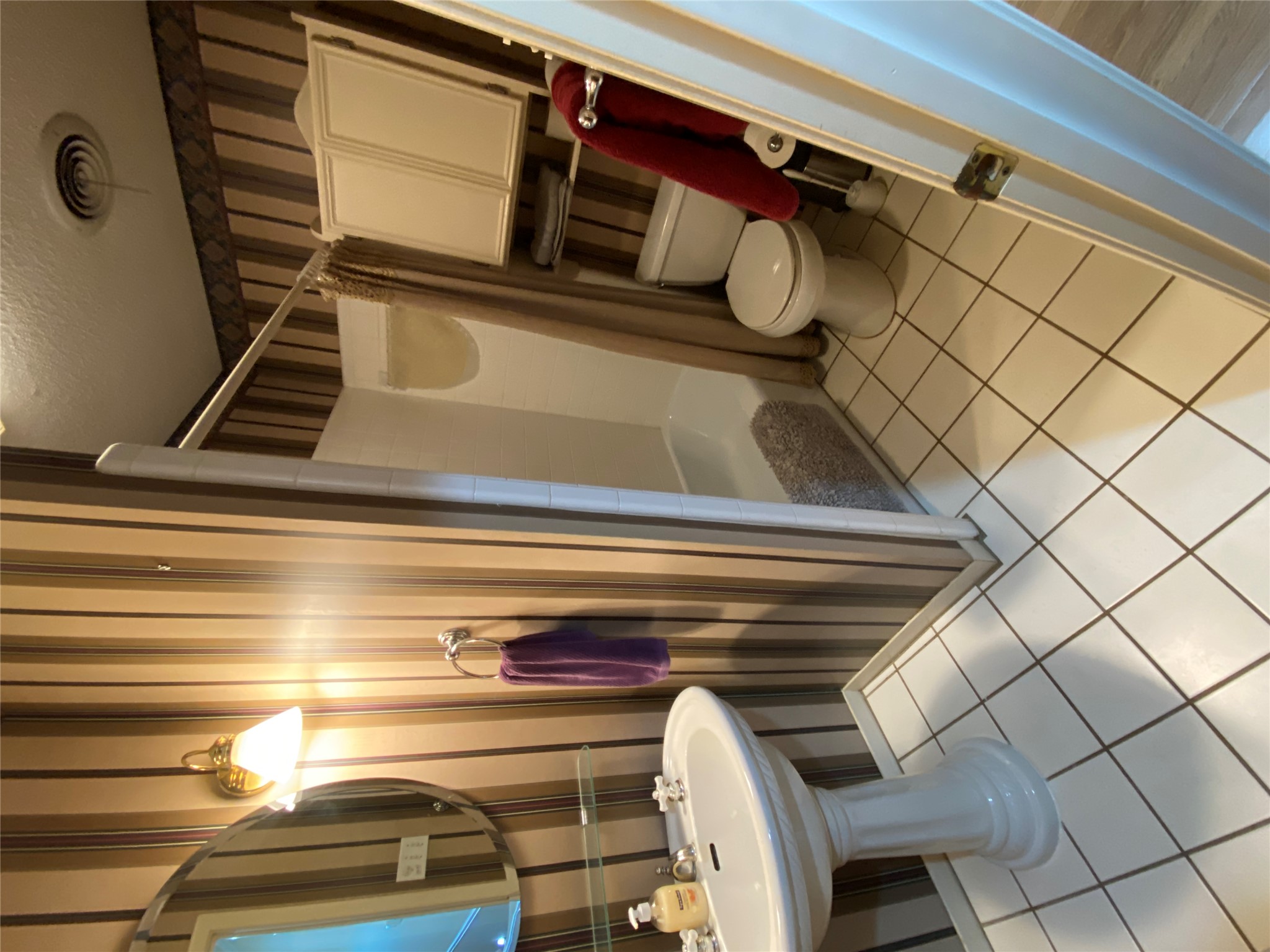 140 Oak Ridge Road Georgetown, TX 78628 - Photo 37 of 39 Bathroom featuring wallpapered walls, a textured ceiling, light tile patterned floors, and shower / bathtub combination with curtain