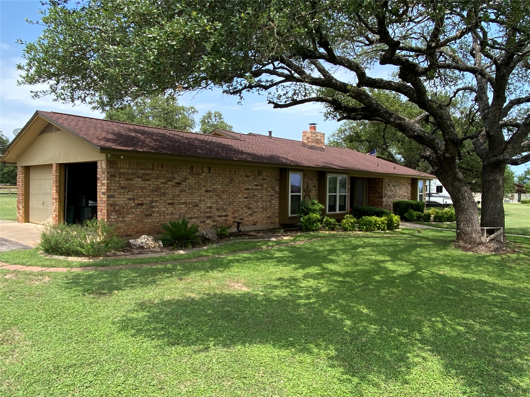 140 Oak Ridge Road Georgetown, TX 78628 - Photo 5 of 40 Ranch-style house with brick siding, a front lawn, a chimney, and a garage