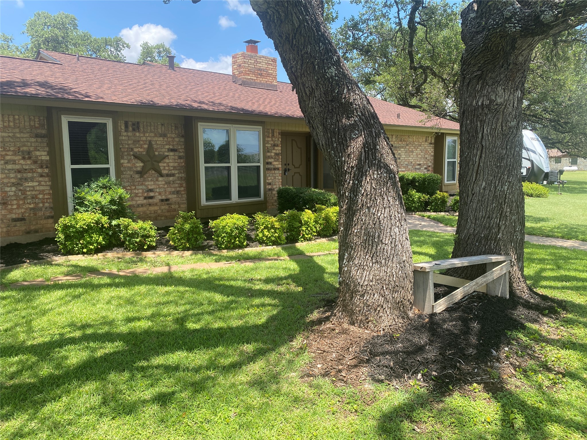 140 Oak Ridge Road Georgetown, TX 78628 - Photo 6 of 40 View of front facade featuring brick siding, a front lawn, a chimney, and roof with shingles