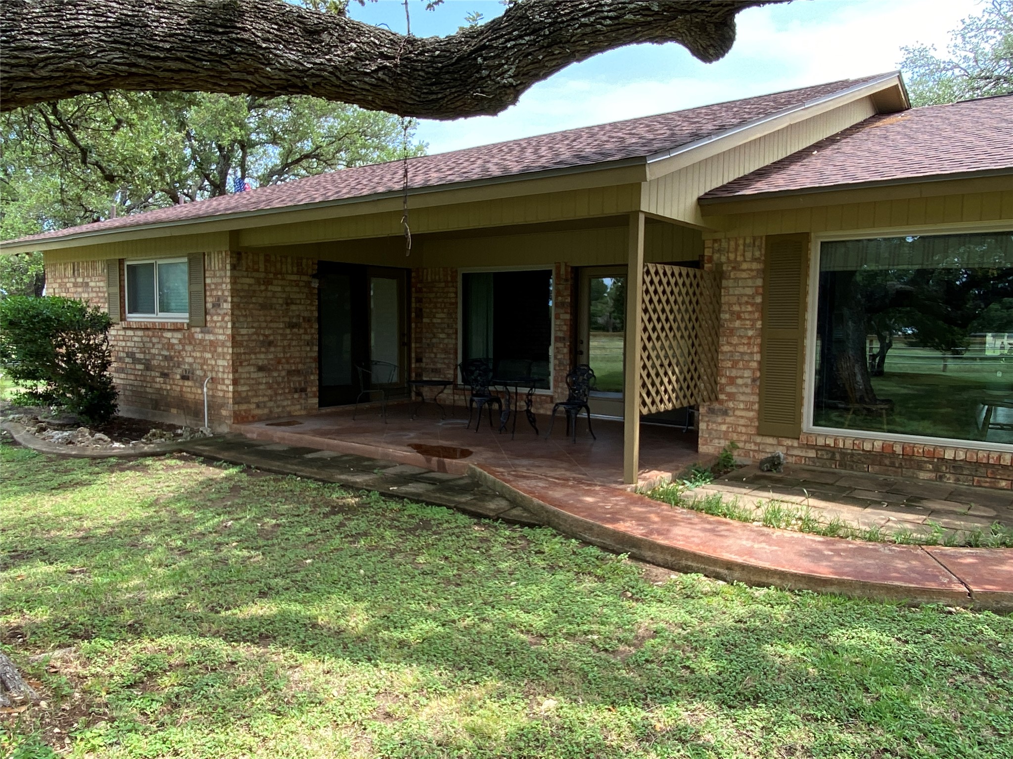 140 Oak Ridge Road Georgetown, TX 78628 - Photo 9 of 40 Rear view of house with brick siding, a shingled roof, a patio, and a lawn