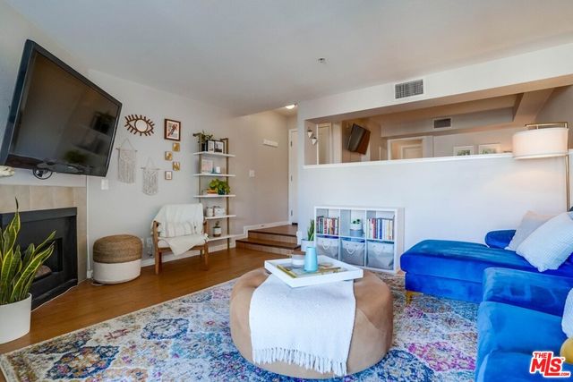 a living room with furniture a flat screen tv and a fireplace