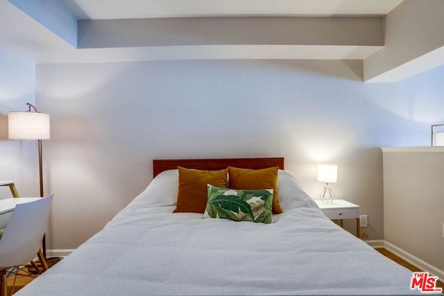 a bed sitting in a bedroom next to a lamp