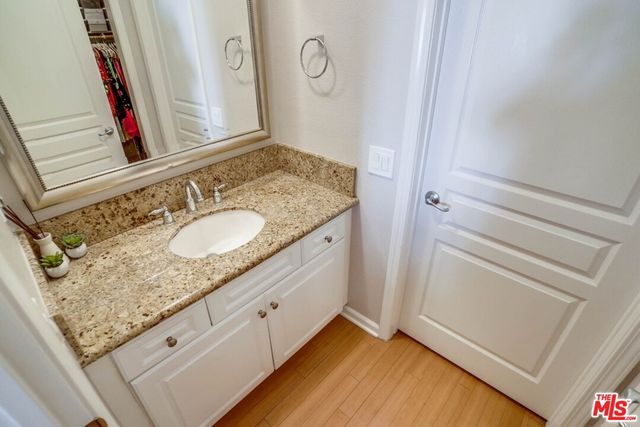 a bathroom with a granite countertop sink and a mirror
