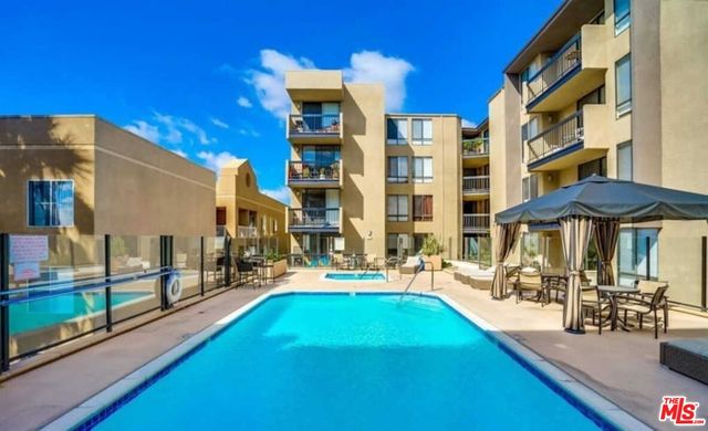a patio with a table and chairs under an umbrella