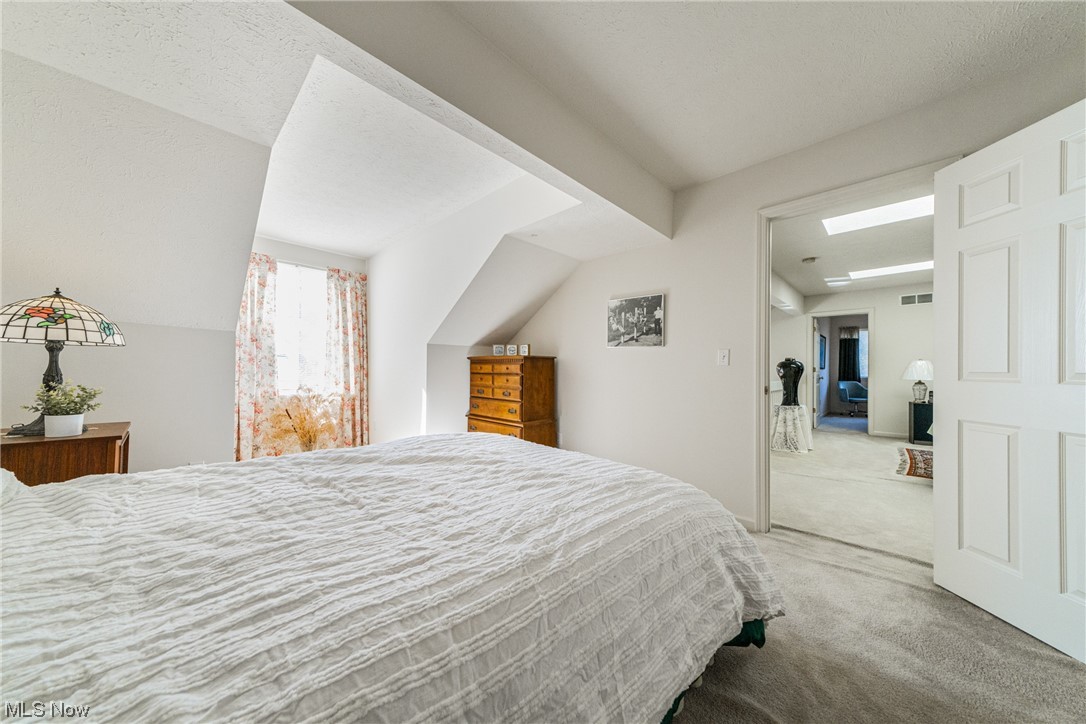 4220 Castle Ridge Akron, OH 44321 - Photo 22 of 35 Bedroom with lofted ceiling, light carpet, and a textured ceiling