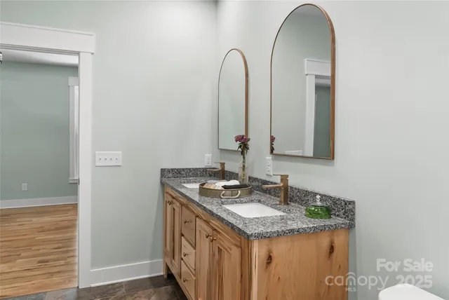 a bathroom with a granite countertop sink and a mirror