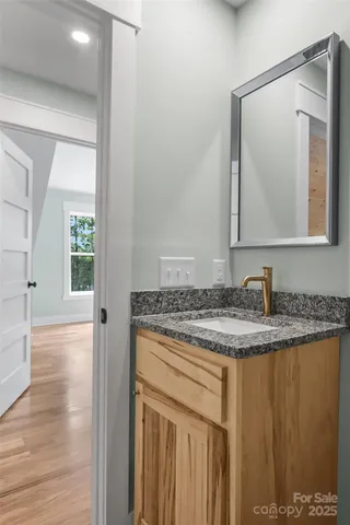 a bathroom with a granite countertop sink and a mirror