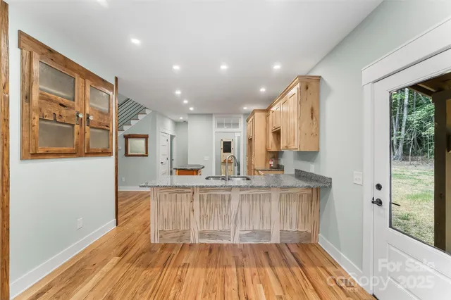 a kitchen with cabinets and wooden floor