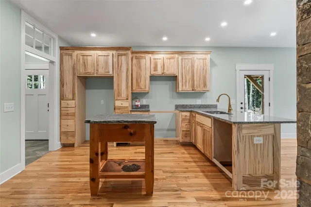 a kitchen with kitchen island granite countertop wooden cabinets and counter space