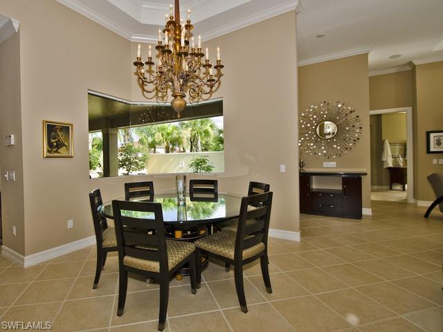 5030 Rustic Oaks Circle Naples, FL 34105 - Photo 3 of 12 a view of a dining room with furniture and chandelier