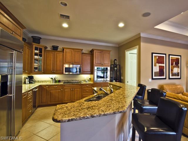 5030 Rustic Oaks Circle Naples, FL 34105 - Photo 6 of 12 a kitchen with a stove sink and refrigerator
