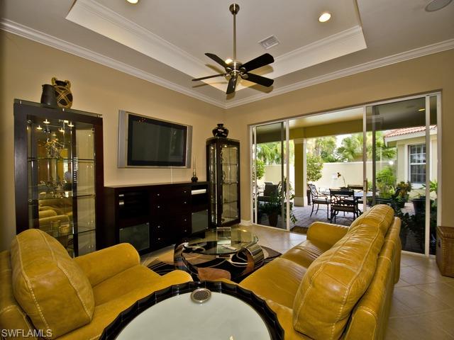 5030 Rustic Oaks Circle Naples, FL 34105 - Photo 7 of 12 a living room with furniture a large window and a flat screen tv