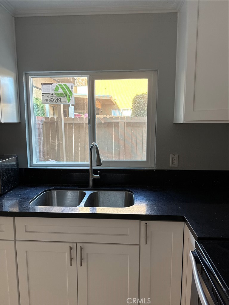 1323 South Standard Avenue, Unit A Santa Ana, CA 92707 - Photo 10 of 11 a kitchen with granite countertop a sink and a white wooden cabinets