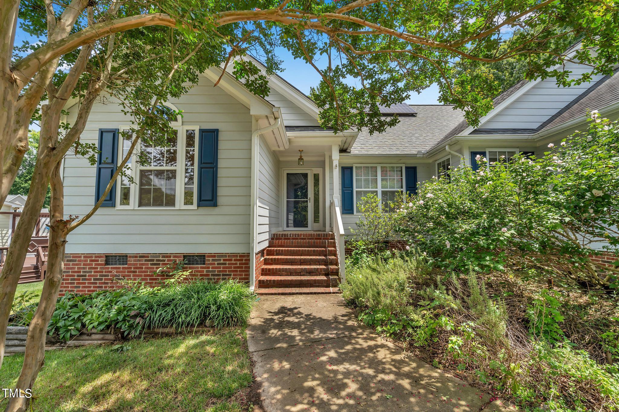 a front view of a house with a garden