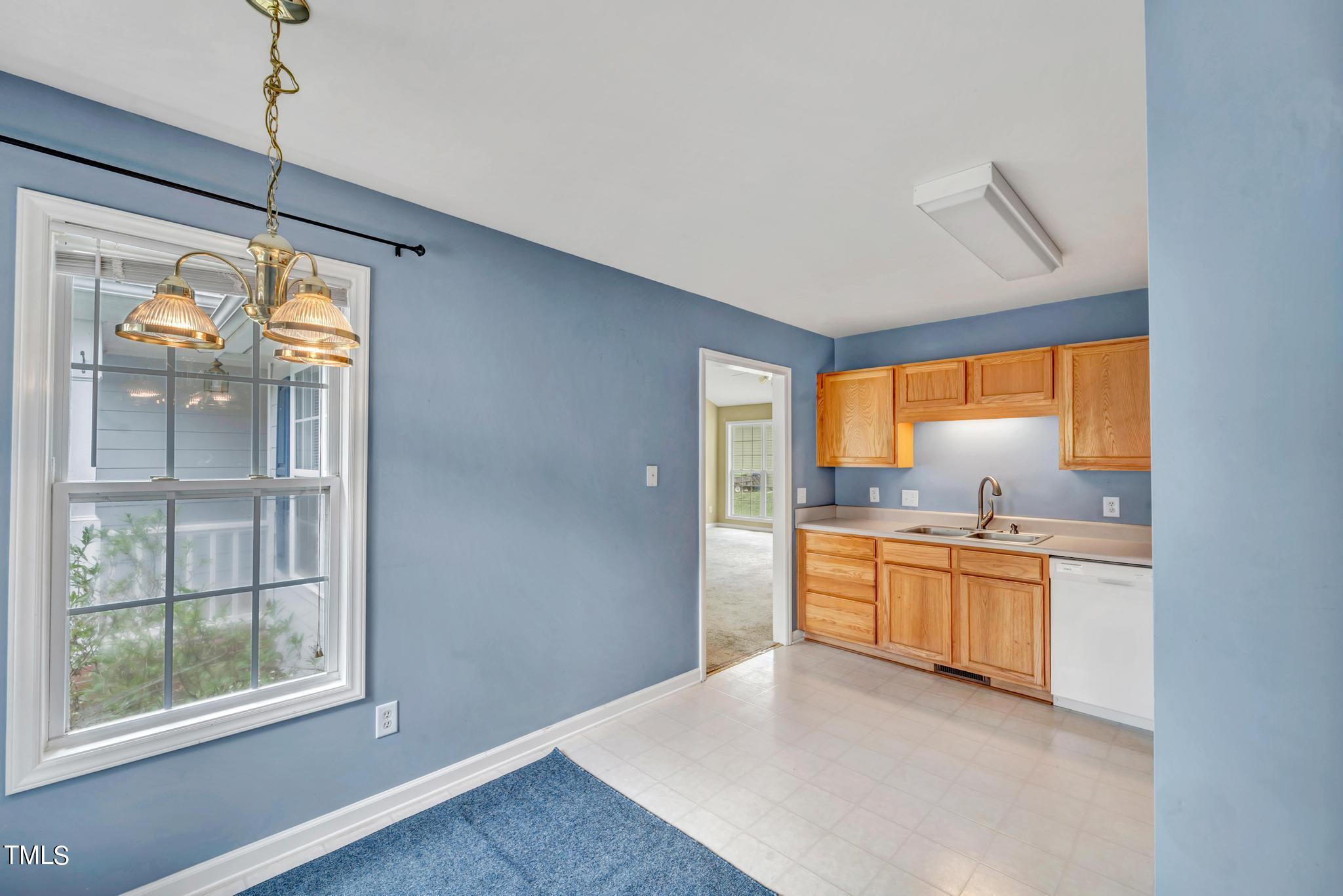 2505 Tryon Pines Drive Raleigh, NC 27603 - Photo 10 of 21 a open kitchen with granite countertop a refrigerator a sink a stove a dining table and chairs with wooden floor