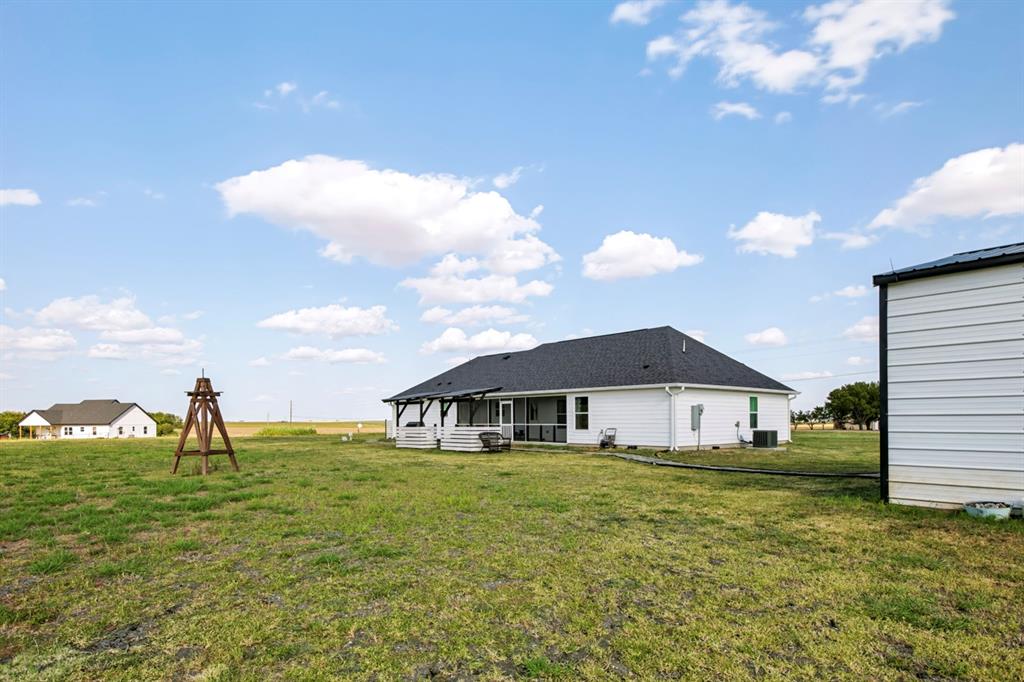 2433 Trlica Road West, TX 76691 - Photo 34 of 40 White siding residence with a dark shingle roof and a screened porch