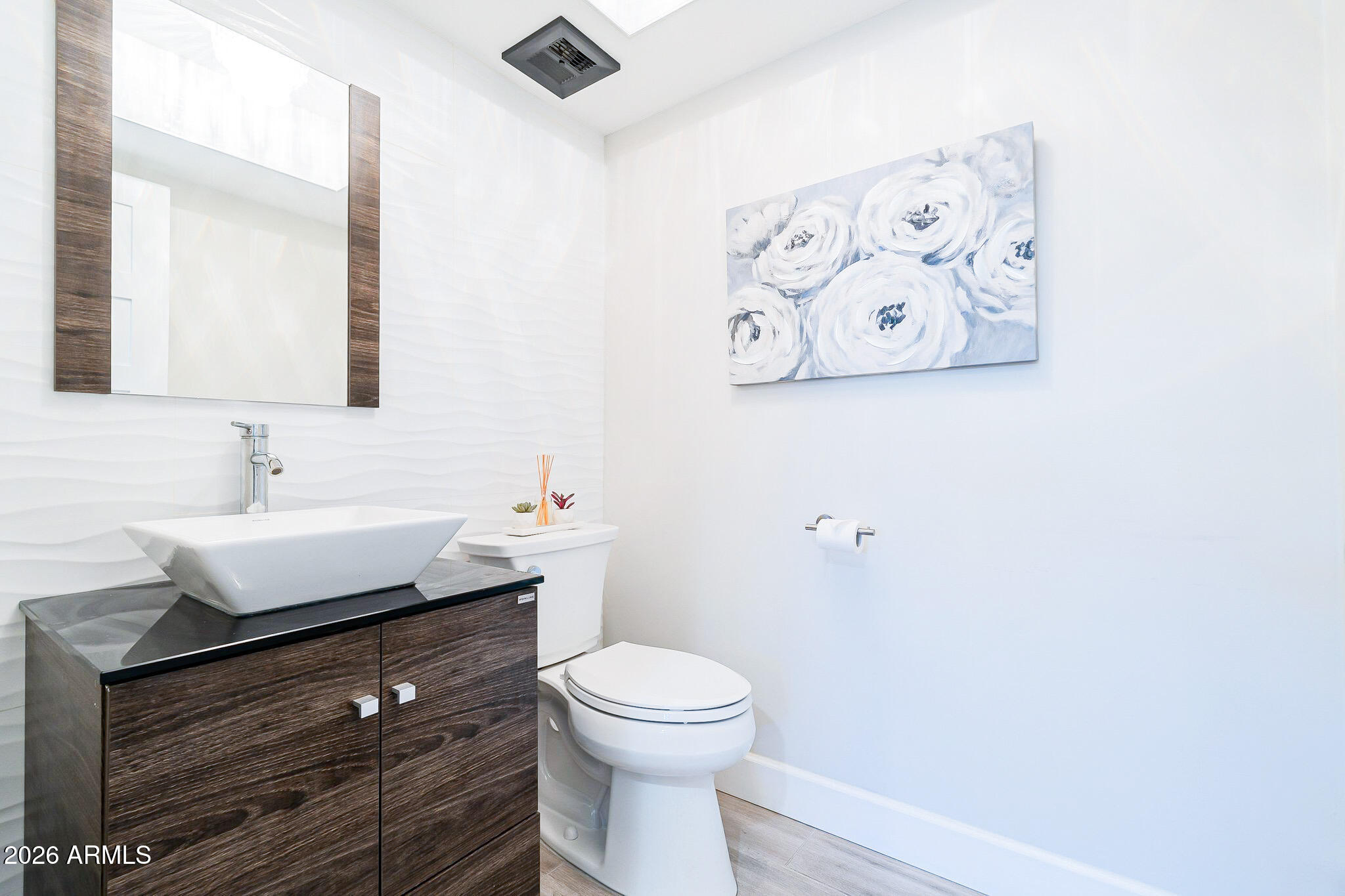 4243 North Miller Road Scottsdale, AZ 85251 - Photo 12 of 24 a bathroom with a toilet a sink and mirror