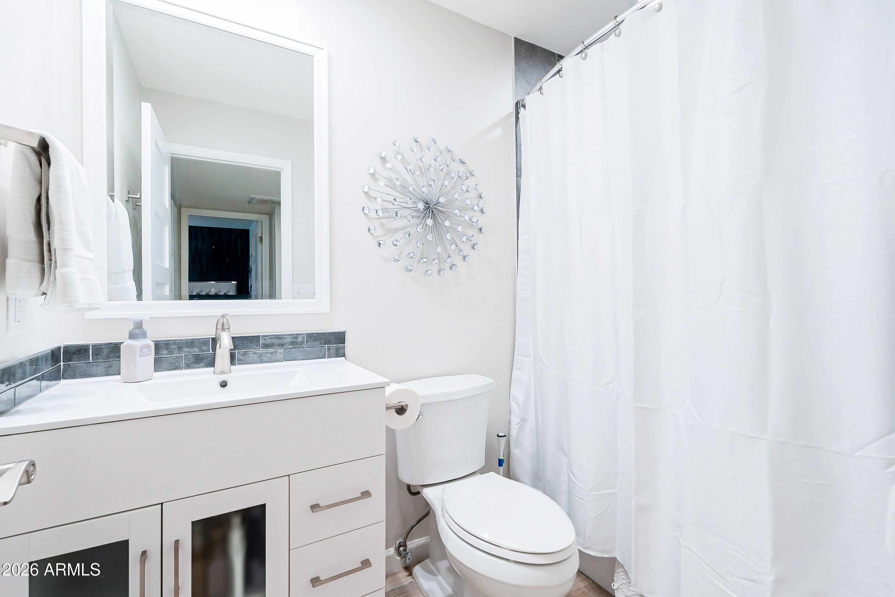 4243 North Miller Road Scottsdale, AZ 85251 - Photo 15 of 24 a bathroom with a toilet sink and mirror