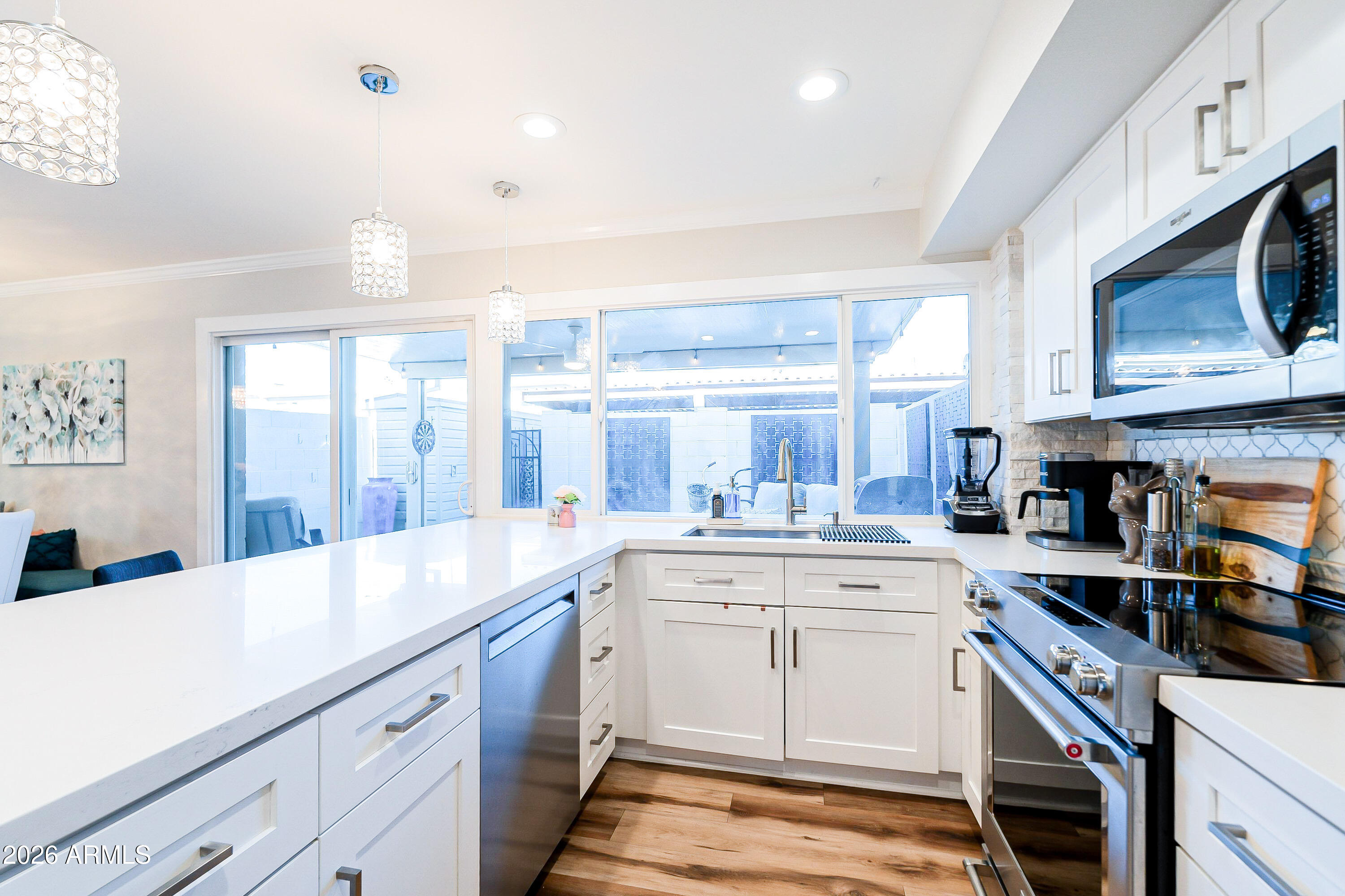 4243 North Miller Road Scottsdale, AZ 85251 - Photo 9 of 24 a kitchen with a sink stove and cabinets