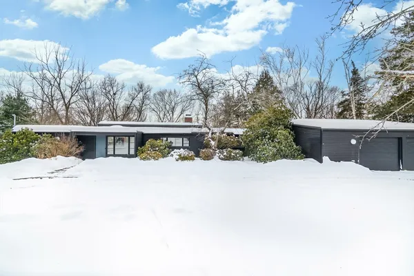 a view of a house with a yard and covered with snow