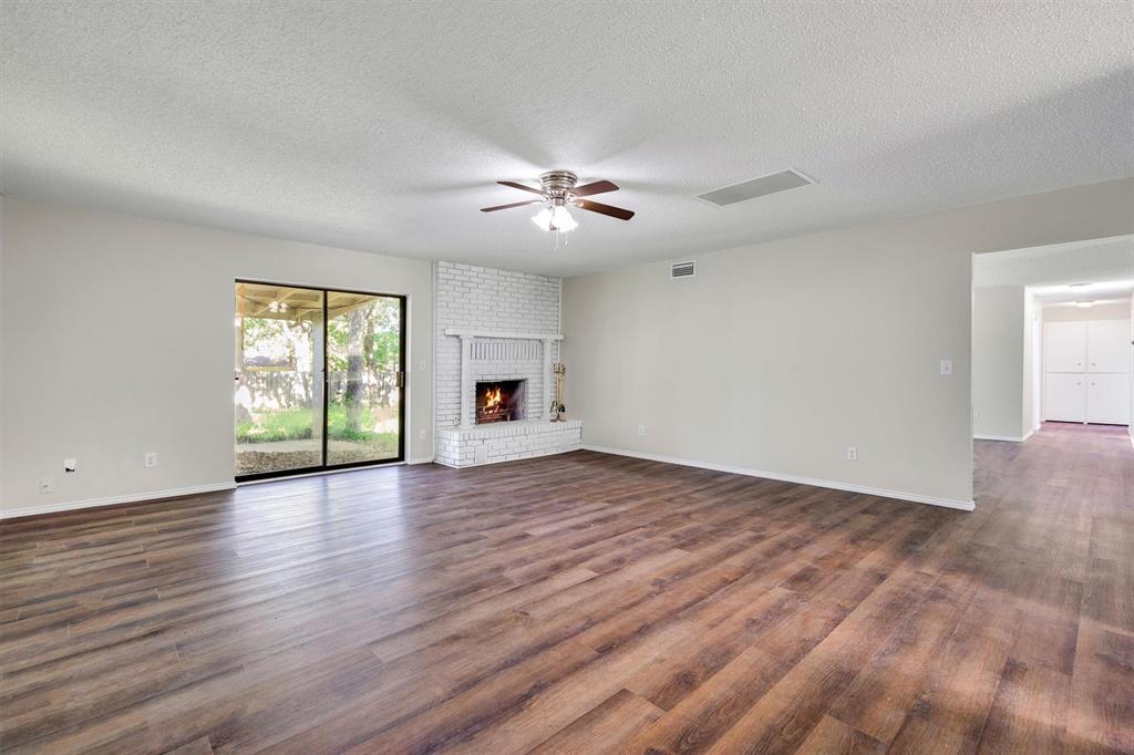 209 Mistletoe Lane Keene, TX 76059 - Photo 7 of 38 a view of empty room with wooden floor and fan