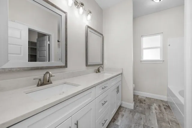 a bathroom with a double vanity sink mirror and