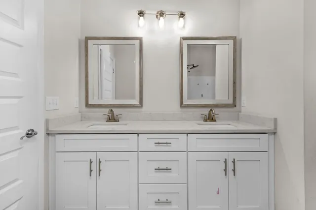 a bathroom with double sink two mirror and a