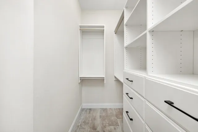 a view of walk in closet with empty racks