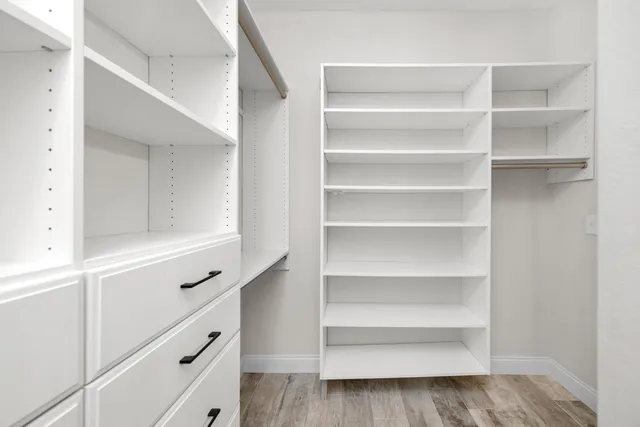a view of walk in closet with empty racks