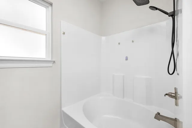 a bathroom with a white bath tub and a shower