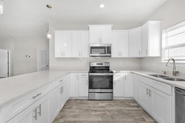 a kitchen with stainless steel appliances granite countertop a sink and a stove