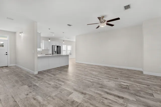 wooden floor in an empty room with a kitchen