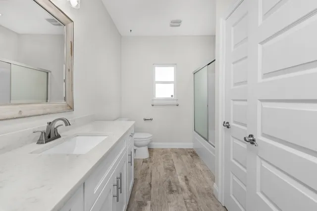 a bathroom with a sink a toilet and shower