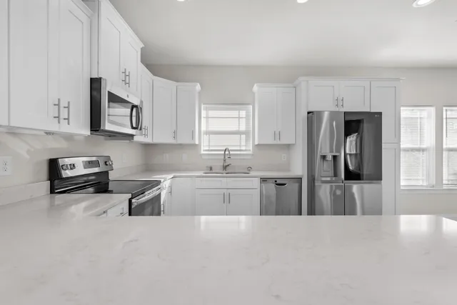 a kitchen with stainless steel appliances granite countertop a refrigerator sink and stove