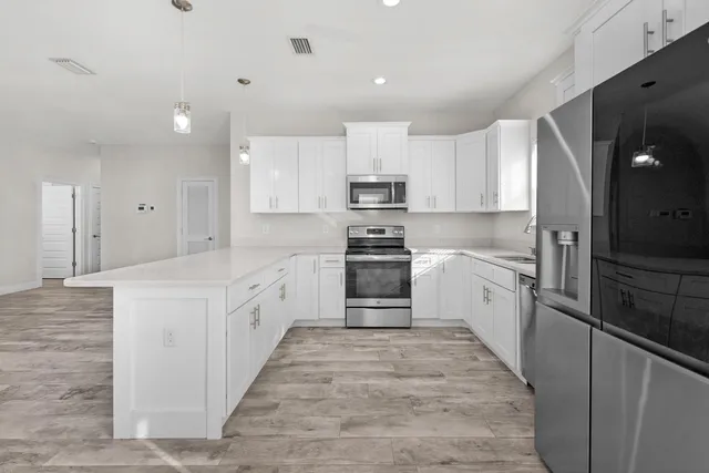 a large kitchen with cabinets and stainless steel appliances