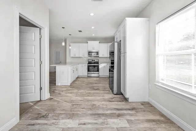a view of a kitchen with a refrigerator and a window