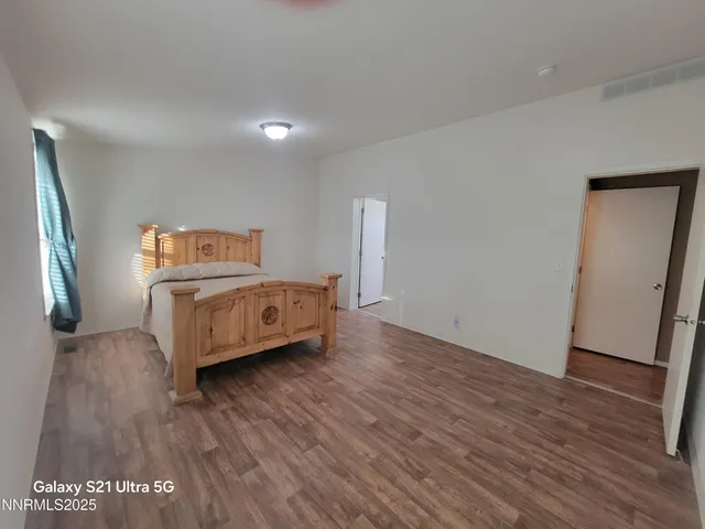 a view of a bedroom with furniture and wooden floor
