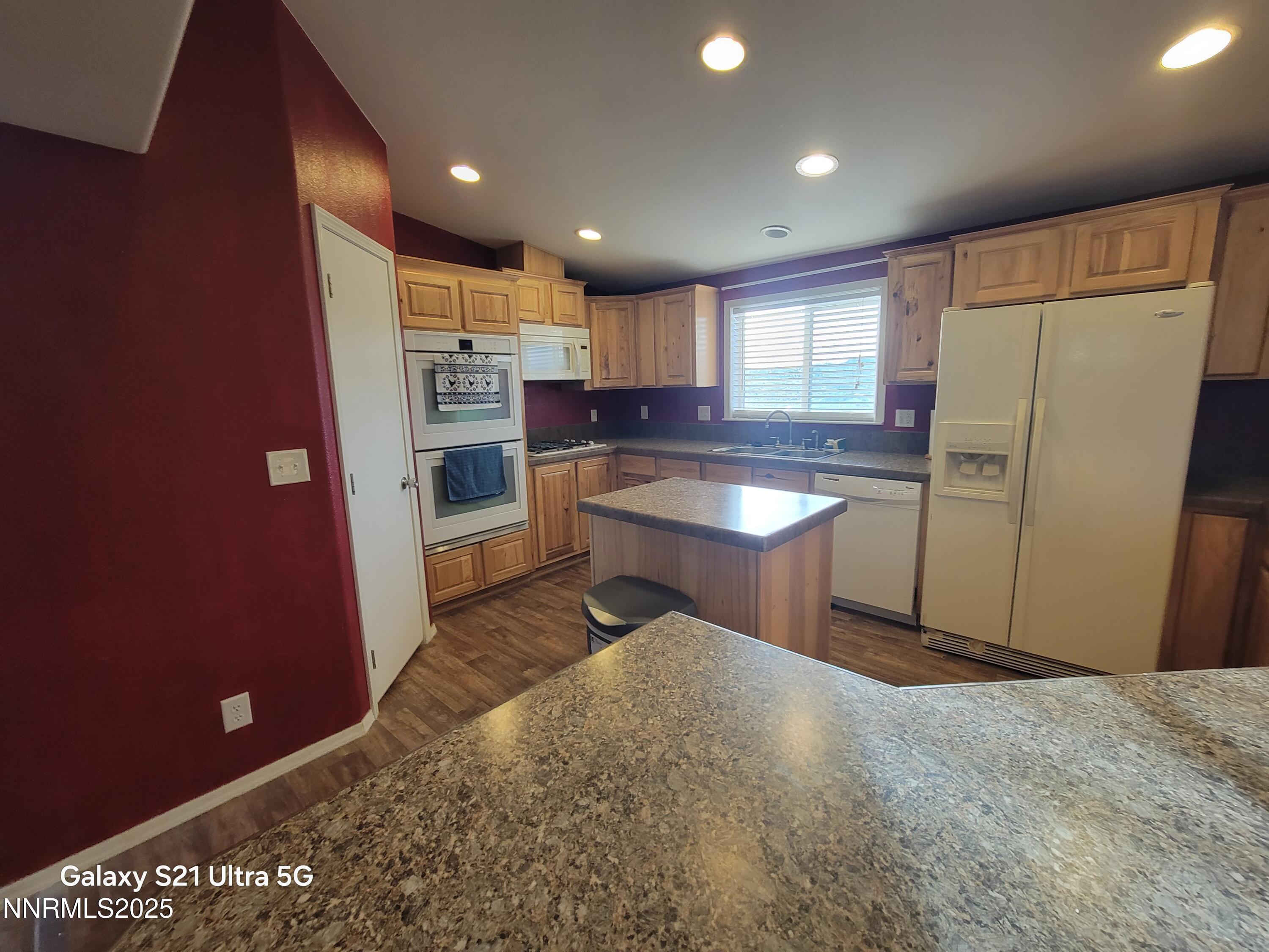 6650 Antelope Circle Austin, NV 89310 - Photo 6 of 25 a kitchen with stainless steel appliances granite countertop a refrigerator a sink a stove a microwave oven with white cabinets and wooden floor