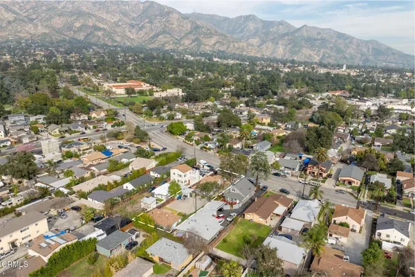 an aerial view of residential houses with outdoor space and trees