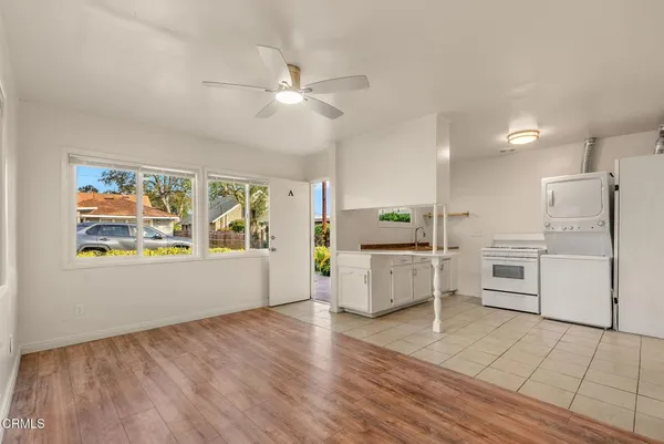 a view of kitchen with microwave a stove and white cabinets