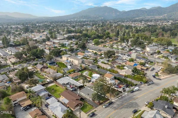 an aerial view of residential houses with outdoor space and trees