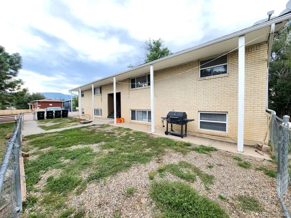 a view of a house with backyard and sitting area