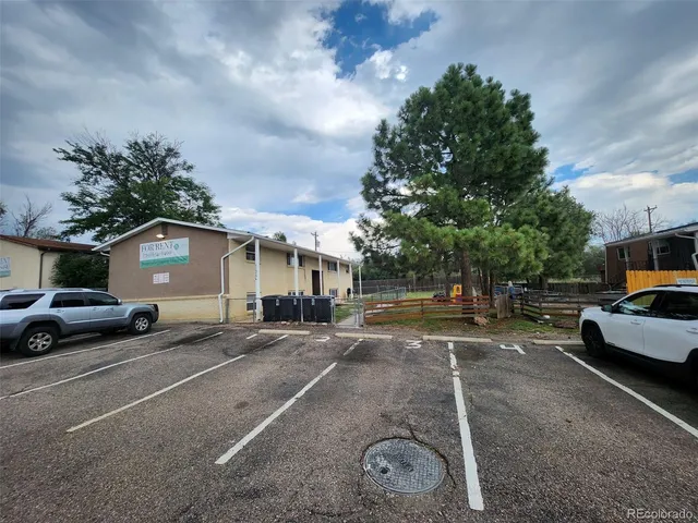 a view of a white house with a big yard and large trees