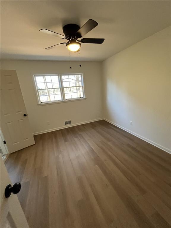 3425 New MacLand Road Powder Springs, GA 30127 - Photo 16 of 21 an empty room with wooden floor chandelier fan and windows
